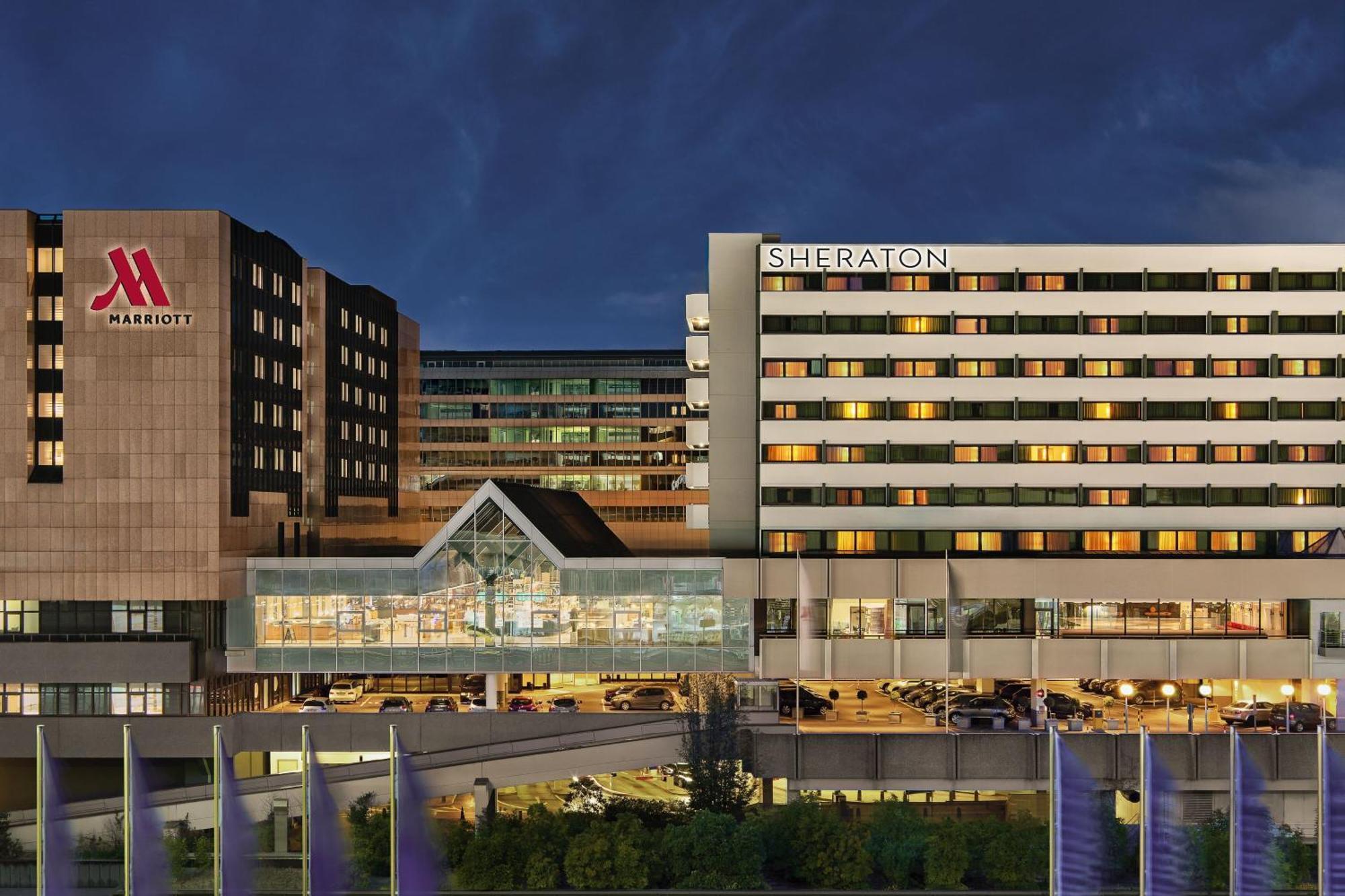 Frankfurt Airport Marriott Hotel Φραγκφούρτη Εξωτερικό φωτογραφία The photo shows two large hotels, the Marriott and the Sheraton, situated next to each other. The buildings appear modern with multiple stories, featuring large windows. The Sheraton hotel is prominently displayed, while the Marriott logo is visible 